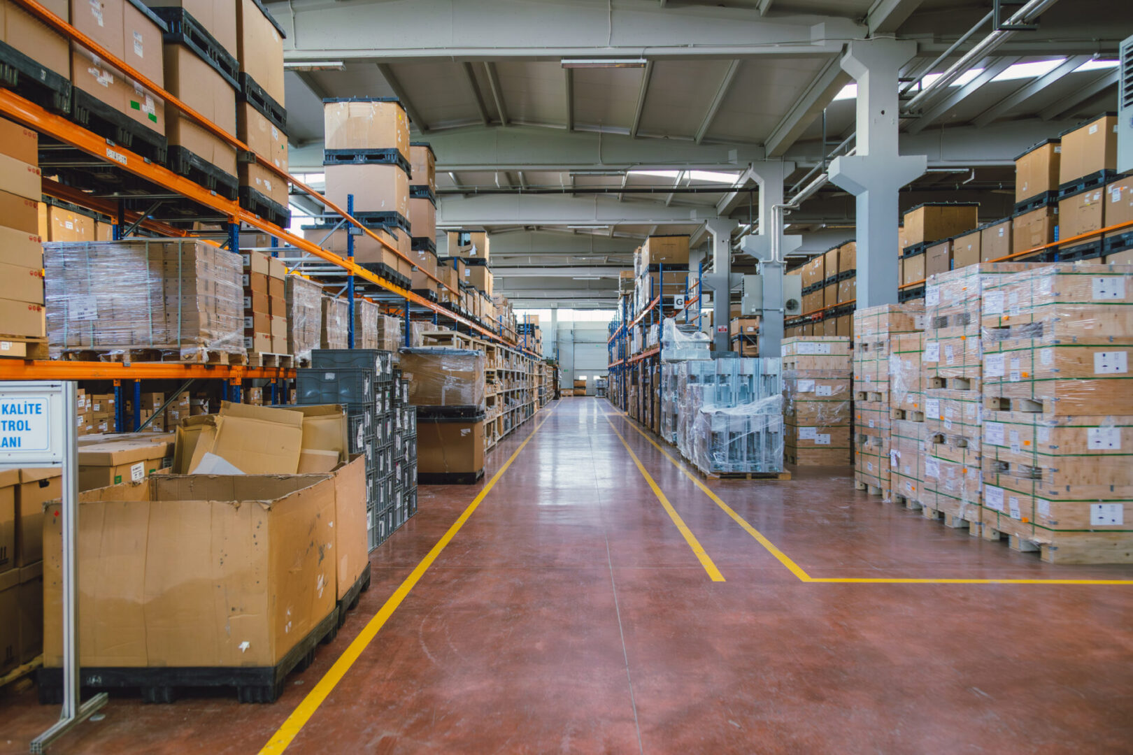Warehouse aisle with stacked boxes and shelves.
